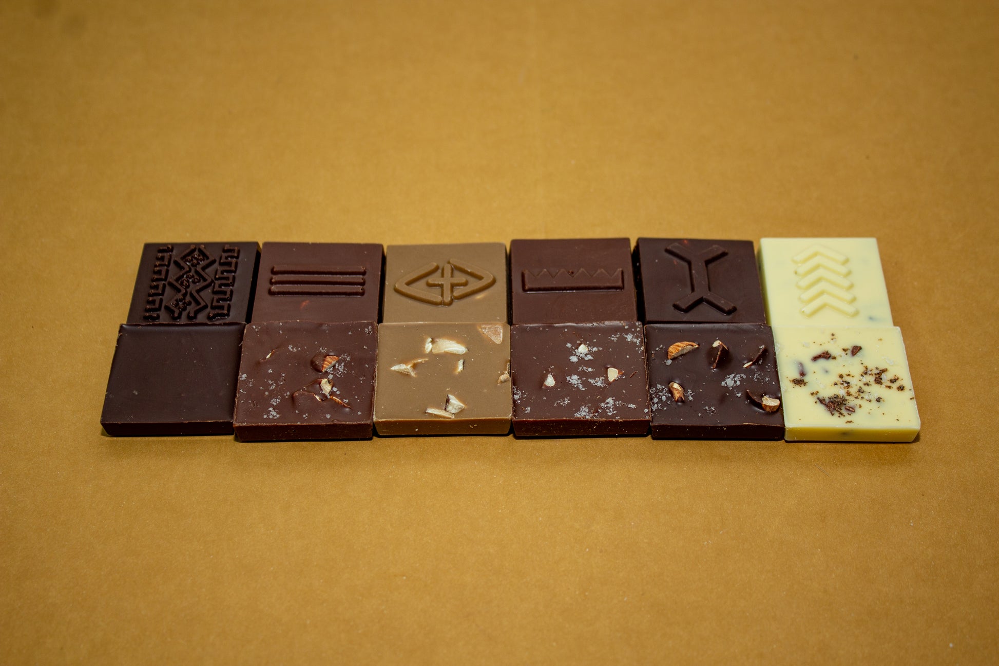 Various chocolate squares engraved with Bogolan symbols.