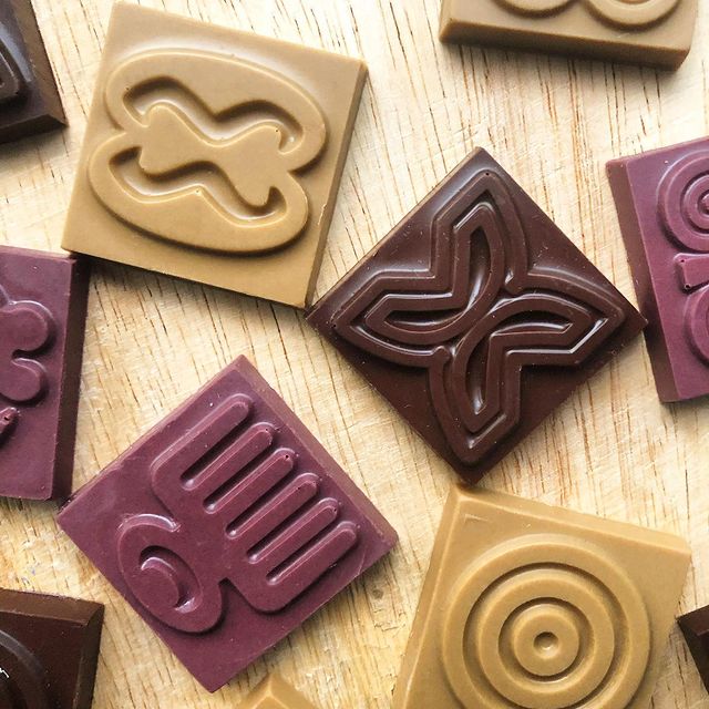 Bite-sized chocolate with adinkra symbols.